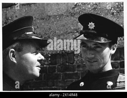 AFS FILM ACTORS: THE FILMING OF 'UNPUBLISHED STORY' IN DENHAM FILM STUDIOS, DENHAM, BUCKINGHAMSHIRE, ENGLAND, GROSSBRITANNIEN, 1941: die Fahrer C Davidge (links) und M J Allaway (rechts) unterhalten sich im Sonnenschein nach den Dreharbeiten des Films „Unpublished Story“ der Two Cities Film Company. Regie führte Harold French und die Hauptrollen Richard Greene und Valerie Hobson. Es spielt während des Blitz auf den Londoner Docks im Jahr 1940. Laut der Originalüberschrift erzählt Allaway die Geschichte von seiner „16“-Entfernung von einer Bombe, als sie in der Themse fiel“. Stockfoto