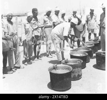 LEBEN IN Einem LIBYSCHEN GEFANGENENLAGER - Gefangene beobachten, wie ihr Abendessen gekocht wird, British Army Stockfoto