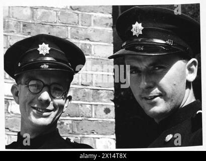 AFS FILM ACTORS: THE FILMING OF 'UNPUBLISHED STORY' IN DENHAM FILM STUDIOS, DENHAM, BUCKINGHAMSHIRE, ENGLAND, GROSSBRITANNIEN, 1941: Uxbridge Hilfsfeuerwehrmänner mit Feuerwehrmann W Griffin (links) und Hilfsfeuerwehrmann E Pearce (rechts) unterhalten sich bei Sonnenschein nach den Dreharbeiten des Films Unpublished Story der Two Cities Film Company. Regie führte Harold French und die Hauptrollen Richard Greene und Valerie Hobson. Laut der Originalunterschrift ist Griffin ein Fahrer und Pearce läutet die Glocke des Feuerwehrgeräts Stockfoto