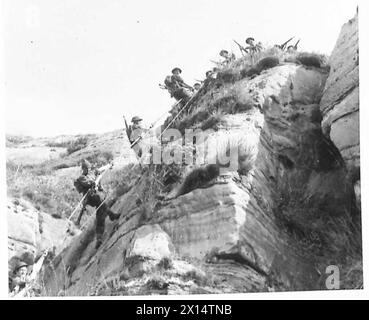 LIFE AT COASTAL DEFENSE BATTERIES - Cliff Scaling ist Teil des Lehrplans einer der Batterien und trägt dazu bei, die Männer in einem perfekten Zustand der körperlichen Fitness zu halten. Verschiedene Waffen werden von den Männern während der Climb British Army getragen Stockfoto