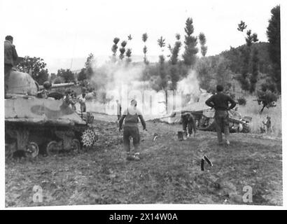 8. ARMEE: REGEN VERLANGSAMT DEN VORMARSCH - dieser Sherman-Panzer der 6. Südafrikanischen Panzerdivision wurde verstopft, als er die Straße verließ, um ein Feld zu überqueren, das sich unter den starken Regenfällen in Schlamm verwandelt hatte. Der Panzer wird von einer anderen Sherman British Army auf festen Boden geschleppt Stockfoto