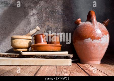 Alte Keramikkkanne zusammen mit anderen Holz- und Keramikutensilien Stockfoto