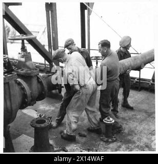RASC-Mitarbeiter und italienische Pioniere positionieren einen 18-Zoll-Schlauch an Bord der „Empire Emerald“ an den Ancona Docks. Stockfoto