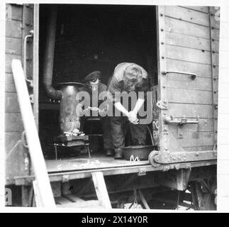 WIE EINIGE BRITISCHE TRUPPEN IN HOLLAND LEBEN - einige Männer der Eisenbahnbaufirma Coy von 607 leben in Eisenbahnwaggons auf einem Anschlussgleis. Spr. Remington aus Liverpool verbringt seine Freizeit damit, ein Buch in seiner „Wagonette“ zu lesen. Diese Wagen sehen vielleicht nicht so gut aus, aber die Männer finden sie recht bequem und jeder Wagen ist mit einem Herd ausgestattet, British Army, 21st Army Group Stockfoto