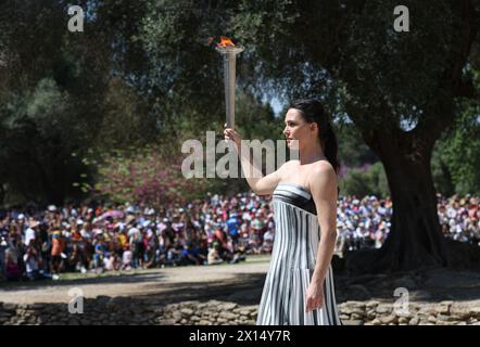 Das Antike Olympia, Griechenland. April 2024. Die griechische Schauspielerin Mary Mina, die die Rolle der Hohepriesterin spielt, hält die Flamme während der letzten Generalprobe der olympischen Flammenzündung für die Olympischen Sommerspiele 2024 im antiken Olympia, Griechenland, am 15. April 2024. Quelle: Li Jing/Xinhua/Alamy Live News Stockfoto