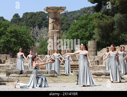 Das Antike Olympia, Griechenland. April 2024. Die griechische Schauspielerin Mary Mina (Front R), die die Rolle der Hohepriesterin spielt, zündet die Flamme während der letzten Probe der olympischen Flammenbeleuchtung für die Olympischen Sommerspiele 2024 im antiken Olympia, Griechenland, am 15. April 2024 an. Quelle: Li Jing/Xinhua/Alamy Live News Stockfoto