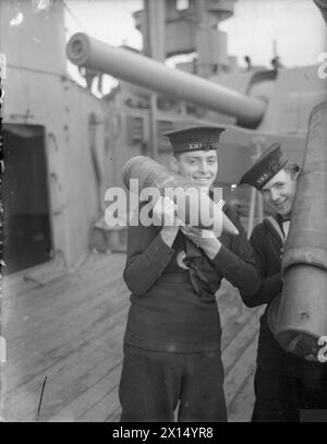 AN BORD DER HMS RODNEY. SEPTEMBER 1940, AN BORD DES SCHLACHTSCHIFFES UND IM HAFEN. - 100 kg Sprengstoff auf der Schulter einer jungen Bewertung Stockfoto