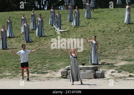 Das Antike Olympia, Griechenland. April 2024. Eine Schauspielerin (Front), die die Rolle einer alten Priesterin spielt, lässt eine Taube bei der letzten Probe der olympischen Flammenbeleuchtung für die Olympischen Sommerspiele 2024 im antiken Olympia, Griechenland, am 15. April 2024 frei. Quelle: Zhao Dingzhe/Xinhua/Alamy Live News Stockfoto