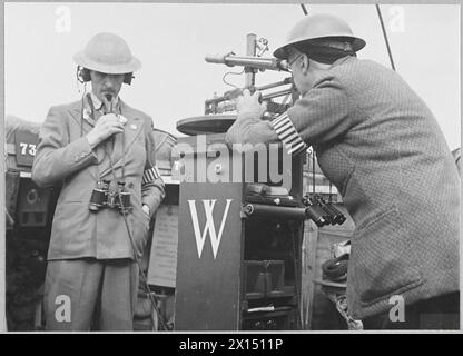 An einem Posten des Observer Corps in einem hohen Gebäude bediente ein Beobachter ein Aufnahmegerät, während ein anderer den Fortschritt des Schlachtzugs an das Fighter Command weitergab. Stockfoto