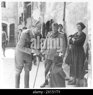 ITALIEN : PRINZ UMBERTO : INSPEKTOR ITALIENISCHES BEFREIUNGSKORPS - Prinz Umberto, umgeben von einer Gruppe bewundernder Qomenvolk, erhält einen Blumenstrauß von einem kleinen Kind der britischen Armee Stockfoto