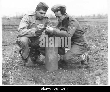 ITALIEN : FÜNFTE RÜSTUNGSMÄNNER, DIE "NEIN" ZUM GENERAL SAGEN - S/SGT. P.L. Voland aus Wisconsin und CPL. W. Swan sehen besorgt aus, als sie mit einem Messstab die jüngste britische Armee des Regenfalls messen Stockfoto