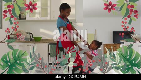Bild von Pflanzen und Blumen über glücklicher afroamerikanischer Mutter und Tochter, die in der Küche tanzen Stockfoto