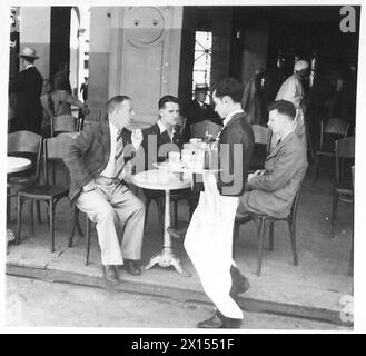 „SPARKS“, „CHIPPY“ UND „VIERTER“ GEHEN AN LAND – um die Zeit vor der Kinoshow zu vertreiben, begeben sich die Männer in ein nahegelegenes Café, um einen Drink der British Army zu trinken Stockfoto