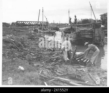 ÜBERQUERUNG DES RUBICON - zerstörerische Szenen im Fluss Rubicon die Brücke im Hintergrund wurde aufgenommen, bevor der Feind Zeit hatte, sie zu zerstören, aber die Eisenbahnbrücke, die entlang lief, wurde durch die britische Armee gesprengt Stockfoto