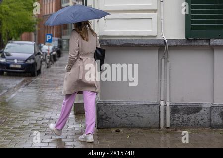 Gent, Belgien. April 2024. Eine Frau mit einem Regenschirm läuft am Montag, den 15. April 2024, durch stürmisches Wetter in Gent. BELGA FOTO JAMES ARTHUR GEKIERE Credit: Belga News Agency/Alamy Live News Stockfoto