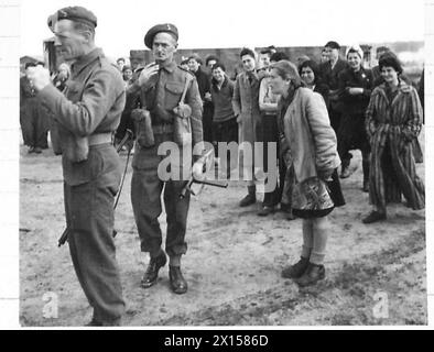 DIE BEFREIUNG DES KONZENTRATIONSLAGERS BERGEN-BELSEN, APRIL 1945 – Hela Goldstein, eine polnische Häftlinge, ist im mittleren Vordergrund zu sehen. Sie wurde in einer jüdischen Familie in Tuszyn in Zentralpolen geboren, was vier Jahre in Konzentrationslagern bedeutete. Sie war in den Lagern Łódź (Litzmannstadt), Auschwitz und Bergen-Belsen (nur zwei Wochen vor der Ankunft der britischen Truppen in Belsen). Britische Truppen halten die weiblichen Häftlinge davon ab, SS-Wachen anzugreifen, während sie LKWs mit Leichen toter Häftlinge beladen, 21. April 1945 British Army, Goldstein, Helena Stockfoto