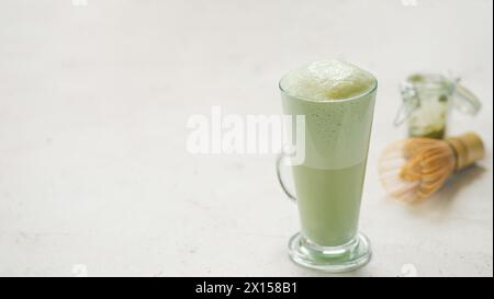 Matcha-Grüntee-Latte im Glas. Matcha Latte auf hellem Hintergrund. Kopierbereich. Banner Stockfoto