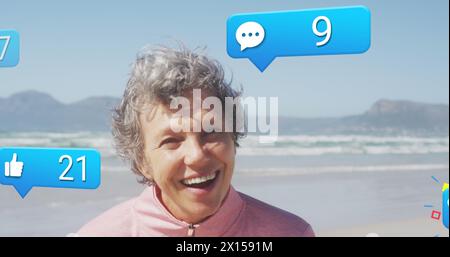 Bild der Datenverarbeitung in sozialen Medien über kaukasische Frau, die am Strand lächelt Stockfoto