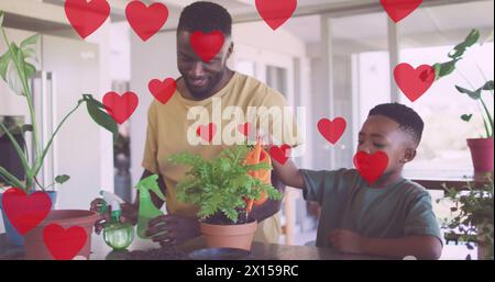 Ein Bild von Herzen über glückliche afroamerikanische Vater- und Sohn-Gartenarbeit Stockfoto