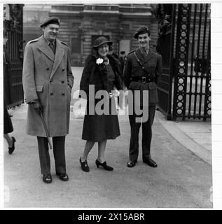 EINSETZUNG IM BUCKINGHAM PALACE - Major General R. Gale, DSO.,OBE.,MC., der die 6. Luftlandedivision in der Normandie befehligte [D-Day], fotografierte vor dem Palast mit seiner Frau und dem ADC, nachdem er die britische Armee empfangen hatte Stockfoto