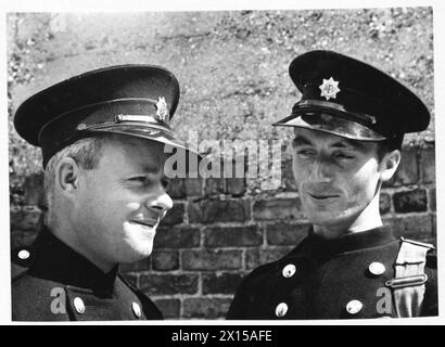 AFS FILM ACTORS: THE FILMING OF 'UNPUBLISHED STORY' IN DENHAM FILM STUDIOS, DENHAM, BUCKINGHAMSHIRE, ENGLAND, GROSSBRITANNIEN, 1941: die Fahrer C Davidge (links) und M J Allaway (rechts) unterhalten sich im Sonnenschein nach den Dreharbeiten des Films „Unpublished Story“ der Two Cities Film Company. Regie führte Harold French und die Hauptrollen Richard Greene und Valerie Hobson. Es spielt während des Blitz auf den Londoner Docks im Jahr 1940. Laut der Originalüberschrift erzählt Allaway die Geschichte von seiner „16“-Entfernung von einer Bombe, als sie in der Themse fiel“. Stockfoto