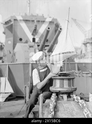 DESTROYER'S MODEL YACHT CLUB. 5. DEZEMBER 1943, MALTA. MÄNNER DER JAGDKLASSE ZERSTÖRER HMS LAUDERDALE HABEN IHREN EIGENEN MODELLYACHT CLUB. - Seaman H L Chitty von Mampton Wick, passt die Walze zu seiner Modellyacht Stockfoto