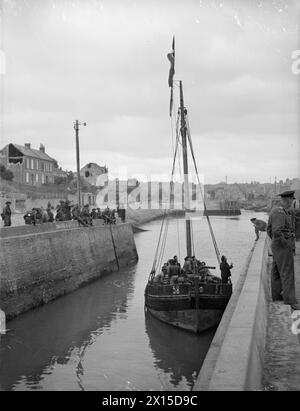 DER FRANZÖSISCHE FISCHEREIHAFEN IST WIEDER NORMAL. 13. JUNI 1944, PORT-EN-BESSON. DAS LEBEN KEHRT ZUR NORMALITÄT ZURÜCK, UND DIE MENSCHEN SIND DAMIT BESCHÄFTIGT, DEN VERBÜNDETEN ZU HELFEN. ALS DIE ROYAL MARINES VON HINTEN EINDRANGEN, FEUERTEN DEUTSCHE FLAKSCHIFFE, DIE IM HAFEN LAGEN, IN DIE STADT UND VERURSACHTEN GROSSEN SCHADEN. - Ein Angel, mit französischen Zivilisten an Bord, um einen französischen Kreuzer zu besuchen Stockfoto