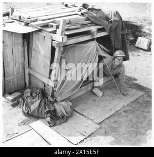 FÜNFTE ARMEE: ANZIO BRÜCKENKOPF 'BESSER 'OLES' AUF DEM ANZIO BRÜCKENKOPF - Pte. L.W. Relton bevorzugt das Zweimannzelt. Das Holzgerüst und die Dachkonstruktion darüber sollen mögliche Muschelfragmente auffangen, die durch ein leichtes Leinenzelt geschnitten und die britische Armee verletzen würden Stockfoto