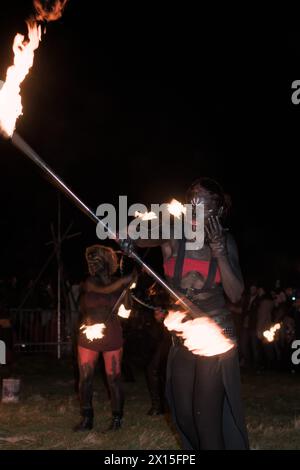 Feuertänzer mit einer Fackel an beiden Enden schwingendes Feuer, das die Nacht durchbricht Stockfoto