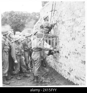 Die SCHOTTISCHE HEIMWACHE klettert mit Hilfe eines Kommandodepot-Ausbilders der British Army über eine Mauer Stockfoto