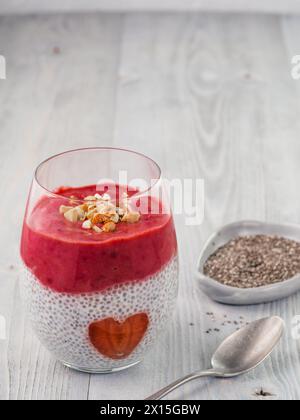 Idee für gesundes Frühstück am Valentinstag: Chia Pudding mit roten Beeren Püree, gehackte Mandeln auf und Erdbeere in der Form des Herzens. Kopieren Sie Platz für Text Stockfoto