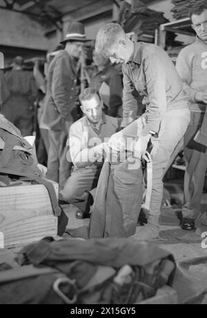 NEW ZEALAND REPATRIATES ARRIVAL IN ENGLAND: ALLTAG FÜR REPATRIIERTE KRIEGSGEFANGENE IN MARGATE, KENT, ENGLAND, Großbritannien, APRIL 1945 - der Privatmann Fred Moroney aus Wellington, Neuseeland, wird im Quartermaster's Store in Margate in eine neue Hose gesteckt. Nach der Originalüberschrift werden neu repatriierte neuseeländische Kriegsgefangene „bei der ersten Gelegenheit komplett mit neuseeländischer Kleidung ausgestattet“ Stockfoto