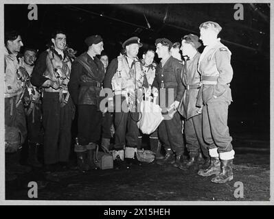 HALIFAX-CREW, DIE AM 4./5. Oktober 1943 in FRANKFURT am MAIN TEILNAHM – nach dem Tagesangriff auf Frankfurt am 4. Oktober 1943 startete das R.A.F. Bomber Command in der Nacht vom 4. Auf den 5. Oktober einen weiteren schweren Angriff auf die deutsche Stadt. Diese Fotos wurden auf einer Station aufgenommen, von der aus viermotorige Halifaxes betrieben wurden. Das Bild (ausgestellt 1943) zeigt: Den Kapitän von 'B' for Beer, Flight Lieutenant A. Carey aus Christchurch, Neuseeland [Mitte] und Mitglieder seiner Crew, die sich mit der Royal Air Force unterhalten Stockfoto