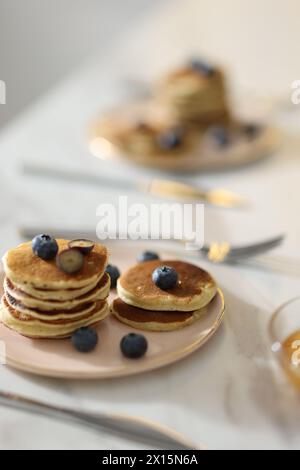 Leckeres Frühstück. Frische Pfannkuchen mit Heidelbeeren auf weißem Marmortisch, selektiver Fokus Stockfoto