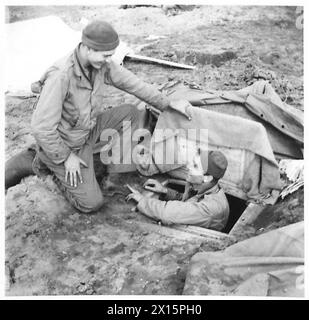 FÜNFTE ARMEE : ANZIO BRÜCKENKOPF 'BETTER 'OLES' AUF DEM ANZIO BRÜCKENKOPF - Pvt. T.H. Duggins aus Madison North Carolina, Route 1, USA (links) gratuliert seinem Freund Pvt. J. Kirby, der einen Schrank aus einem beschädigten Gebäude gerettet und in den Boden gesunken hat und sich dadurch viel Bauarbeit erspart hat. Duggins und Kirby sind beide Ambulanzfahrer des amerikanischen Felddienstes, die für eine britische Unfallversicherungs-Station auf der Bridgehead British Army arbeiten Stockfoto