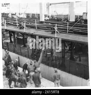 RASC-Mitarbeiter und italienische Pioniere arbeiten daran, einen 18-Zoll-Schlauch an Bord des 'Empire Emerald'-Schiffes in Ancona Docks zu positionieren, um Operationen der britischen Armee zu unterstützen. Stockfoto