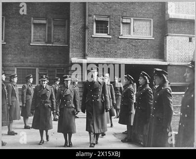 DUCHESS OF GLOUCESTER IM EMPFANGSZENTRUM DER FLUGBESATZUNG - 11980 Foto (ausgestellt 1944) zeigt - begleitet von Gruppenkapitäne A.H.H. Gilligan [Commanding Officer] und Flight Officer L.M. Ouseley, Air Chief Commandant The Duchess of Gloucester, inspiziert W.A.F. im Depot Royal Air Force Stockfoto