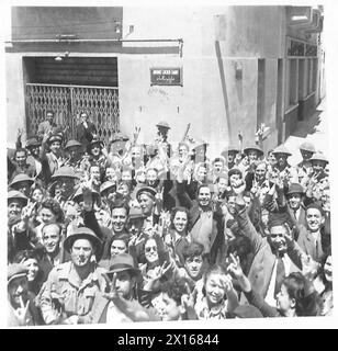 TUNIS - SZENEN NACH DEM FALL DER STADT - Männer des Northants Regiments verbrüdern sich mit Bewohnern, die das „V“-Zeichen der britischen Armee geben Stockfoto