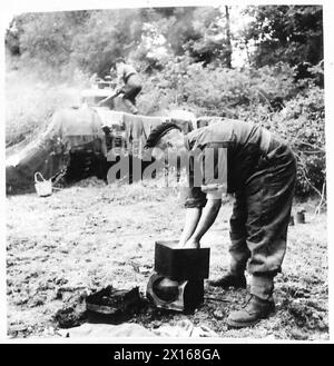 Eine CHURCHILL-BESATZUNG BEREITET SICH AUF DEN KAMPF AUF DAS LEBEN Einer CHURCHILL-PANZERBESATZUNG VOR – die Reinigung muss erfolgen, wenn und wo die Panzerbesatzung ihren Churchill parkt. Hier ist Trooper E. Macquinness, der einige seiner Klamotten in einer improvisierten Schüssel wäscht, britische Armee, 21. Armeegruppe Stockfoto