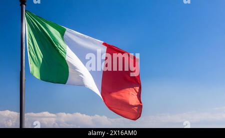 Die Fahne von Italien flattert im Wind, isoliert gegen blauer Himmel Stockfoto