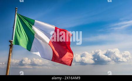 Die Fahne von Italien flattert im Wind, isoliert gegen blauer Himmel Stockfoto