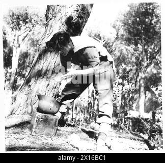 ITALIEN: FÜNFTE ARMEE: ANZIO BRIDGEHEADPTE. JOHNSON - VERSTÄRKUNG DER QUEENS - PTE. Johnson hat eine Waschanlage in einem deutschen Blechhelm, die von seinem ehemaligen Besitzer British Army nicht mehr benötigt wird Stockfoto