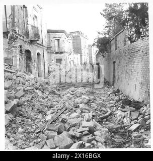 ITALIEN: 8. ARMEEEINTRITT IN ORTONA – eine Infanterie-Patrouille, die eine verfallene Seitenstraße der britischen Armee durchquert Stockfoto