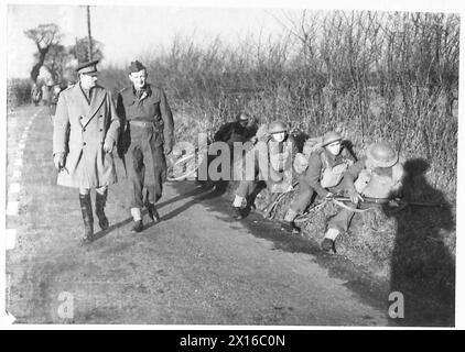 DER BESUCH DES DUKE OF GLOUCESTER IN EAST ANGLIA - H.R.H. überquerte Truppen eines Lancashire-Regiments, die während einer Übung der britischen Armee am Straßenrand Deckung nahmen Stockfoto