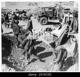 8. ARMEE: WIEDERAUFBAU VON BRÜCKEN UND EISENBAHNEN - Männer des 1218 indischen Pioneer Coy ernähren die hungrigen Kiefer eines Zementmischers auf der Lamone Bridge, British Army Stockfoto