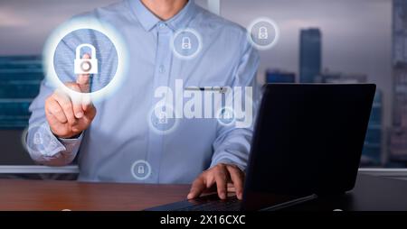 Cybersicherheitskonzept. die führungskraft im Büro vor dem Laptop berührt das Hologramm des Vorhängeschlosses auf einer Leiterplatte. Stockfoto