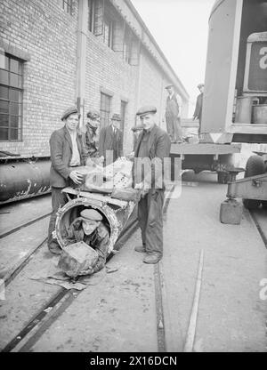 AN BORD DER KAPITULIERTEN U 532. 18. MAI 1945, GLADSTONE DOCK, LIVERPOOL. AN BORD DER U 532 GAB SICH DIE BLOCKADE DES DEUTSCHEN U-BOOTS AUF DEM WEG VON JAPAN MIT EINER LADUNG AUS TIN, CHININ, WOLFRAM UND GUMMI IM ATLANTIK AUF. - Entladung des Gummis aus einem der Rohre, die bündig in das Obergehäuse von U 532 eingebaut sind Stockfoto