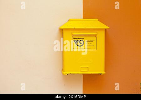 Zadar, Kroatien - 14. April 2019: Gelber kroatischer Briefkasten an einer Mauer des Stadtzentrums. Stockfoto