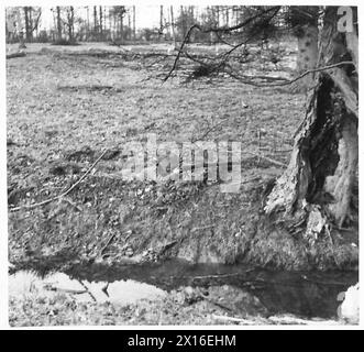 KRIEGSKORRESPONDENTEN BESUCHEN DAS ÖSTLICHE KOMMANDO - Ein Scharfschütze in einem flachen Graben, den er die britische Armee ausgegraben hat Stockfoto