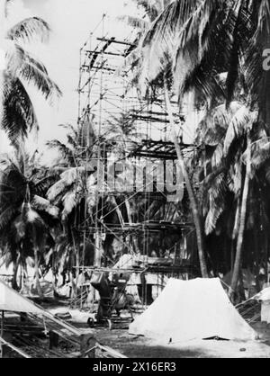 MARINES VERSTÄRKEN GEHEIME TROPISCHE ANKERPLÄTZE. 1944, ADDU ATOLL, MALEDIVEN. DIE DREIECKIGE GRUPPE VON KORALLENBUCHTEN AUF DEN MALEDIVEN, DIE TROTZ DER BENACHTEILIGUNGEN DURCH KRANKHEIT UND DSCHUNGEL HEIMLICH ALS ANKERPLATZ FÜR SCHIFFE BEFESTIGT WURDEN, DIE DIE WEITEN GEBIETE DES INDISCHEN OZEANS ÜBERQUERTEN, DIE IM SEPTEMBER 1941 VON DEN ROYAL MARINES DORTHIN GESCHICKT WURDEN. - Der Turm der Kriegssignalstation wird gebaut Stockfoto